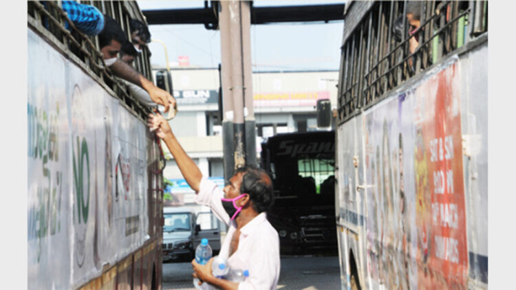 ബീഹാറിലേക്ക് തീവണ്ടി കയറാന്‍ മലപ്പുറത്ത് നിന്നും കോഴിക്കോട് പുതിയ ബസ് സ്റ്റാന്റിലെത്തിയ ഇതര സംസ്ഥാന തൊഴിലാളികള്‍ക്ക് കുടിവെള്ളം വില്‍പ്പന നടത്തുന്നയാള്‍