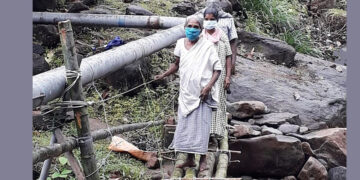 സേവാഭാരതി പ്രവര്‍ത്തകര്‍ നിര്‍മ്മിച്ച് നല്‍കിയ പാലത്തിലുടെ മറുകര കടക്കുന്ന കുടുംബം