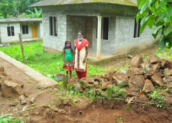 ഗീതയും മകളും പണി തീരാത്ത വീടിന് മുന്നില്‍, സമീപത്തായി കൈയേറി കെട്ടാന്‍ ശ്രമിക്കുന്ന മതിലും കാണാം