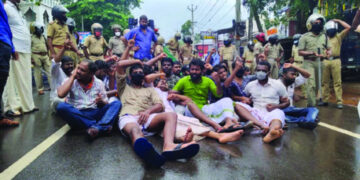 മന്ത്രി മേഴ്‌സിക്കുട്ടി അമ്മയുടെ ഓഫീസിലേക്ക് മാര്‍ച്ച് നടത്തിയ യുവമോര്‍ച്ച പ്രവര്‍ത്തകര്‍ ജലപീരങ്കി പ്രയോഗത്തിന് ശേഷം റോഡിലിരുന്ന് മുദ്രാവാക്യം മുഴക്കുന്നു