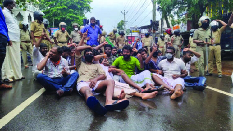 മന്ത്രി മേഴ്‌സിക്കുട്ടി അമ്മയുടെ ഓഫീസിലേക്ക് മാര്‍ച്ച് നടത്തിയ യുവമോര്‍ച്ച പ്രവര്‍ത്തകര്‍ ജലപീരങ്കി പ്രയോഗത്തിന് ശേഷം റോഡിലിരുന്ന് മുദ്രാവാക്യം മുഴക്കുന്നു