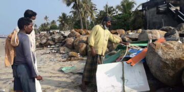 തകര്‍ന്ന വള്ളത്തിന്റെ അവശിഷ്ടങ്ങള്‍ക്കടുത്ത് മത്സ്യത്തൊഴിലാളികള്‍