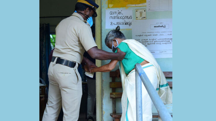 മുളങ്കാടകം ഡിവിഷനിലെ വനിതാഐടിഐയില്‍ വോട്ട് ചെയ്യാനെത്തിയ വൃദ്ധയെ സഹായിക്കുന്ന പോലീസുകാരന്‍