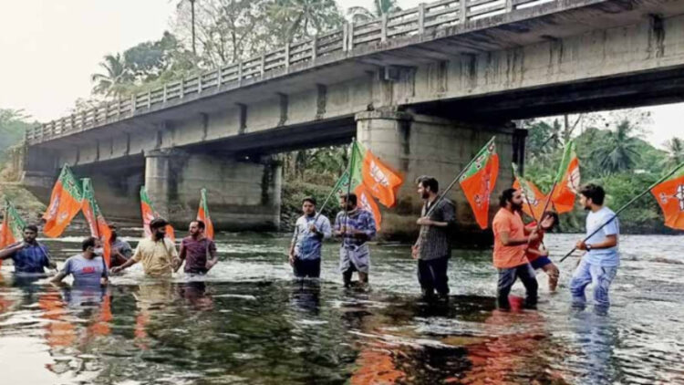 കാഞ്ഞിരമറ്റം- മാരിയില്‍ കലുങ്ക് പാലത്തിന് അപ്രോച്ച് റോഡ് നിര്‍മ്മിക്കാത്തതിനെതിരെ യുവമോര്‍ച്ചയുടെ ആഭിമുഖ്യത്തില്‍ പുഴയിലിറങ്ങി പ്രതിഷേധിക്കുന്നു