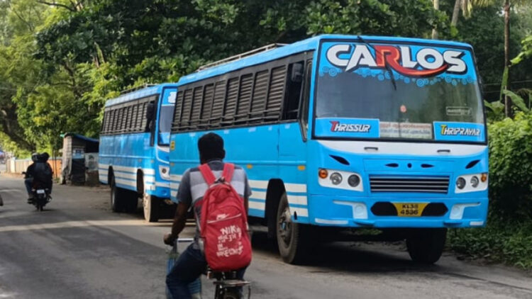 അന്തിക്കാട് പോലീസ് പിടികൂടിയ രണ്ടു ബസുകള്‍ സ്റ്റേഷനോട് ചേര്‍ന്ന് റോഡരികില്‍ പാര്‍ക്ക് ചെയ്തിരിക്കുന്നു