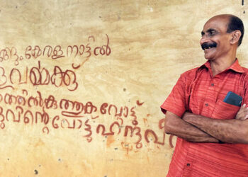 1984 ലെ ലോക്‌സഭ ഹിന്ദു മുന്നണി സ്ഥാനാര്‍ഥി കേരളവര്‍മ്മയുടെ തെരഞ്ഞെടുപ്പിനായി പുന്നാവൂരിലെഴുതിയ ചുമരെഴുത്തിന് അരികില്‍ അന്നത്തെ ശാഖാ കാര്യവാഹ് സുരേഷ് ബാബു