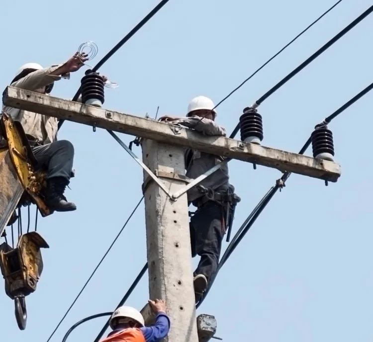 Selective focus of electricians are fixing power transmission line on a electricity pole