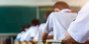 Rear view of middle school students studying in classroom