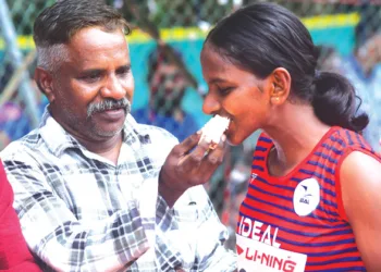 ജൂനിയര്‍ പെണ്‍കുട്ടികളുടെ പോള്‍വാള്‍ട്ടില്‍ സ്വര്‍ണ്ണം നേടിയ കെ.എസ്. അമല്‍ചിത്രയ്ക്ക് അച്ഛന്‍ സുധീഷ് മധുരം നല്‍കുന്നു, കോച്ച് അഖില്‍ കെ.പി. സമീപം