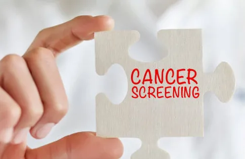 Businesswoman holding jigsaw puzzle pieces with Cancer screening text