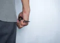 a person's hand is holding a pair of scissors, the concept of being defensive or threatening. photo illustration of murder, robbery.