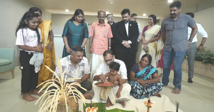 ശിഖയുടെ കൈപിടിച്ച് ആദ്യക്ഷരം എഴുതിക്കുന്ന ഡോ. മാത്യു ജേക്കബ്. ശിഖയുടെ കുടുംബവും ആസ്റ്റര്‍ മെഡ്‌സിറ്റിയിലെ ഡോക്ടര്‍മാരും നഴ്‌സുമാരും മറ്റ് ജീവനക്കാരും സമീപം