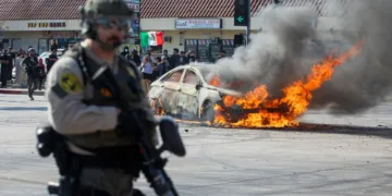 A car burns during a protest following federal immigration operations, in the Compton neighborhood of Los Angeles, California on June 7, 2025. US President Donald Trump deployed 2,000 troops on June 7, 2025 to handle escalating protests against immigration enforcement raids in the Los Angeles area, a move the state's governor termed "purposefully inflammatory." Federal agents clashed with angry crowds in a Los Angeles suburb as protests stretched into a second night Saturday, shooting flash-bang grenades and shutting part of a freeway amid raids on undocumented migrants, reports said. (Photo by RINGO CHIU / AFP)