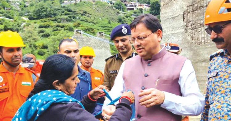 ഉത്തരാഖണ്ഡ് മുഖ്യമന്ത്രി പുഷ്‌കര്‍ സിങ് ധാമിയുടെ കൈയില്‍ ധന്‍ ഗൗരി സാരിയുടെ മുന്താണി കീറി രാഖി ബന്ധിക്കുന്നു