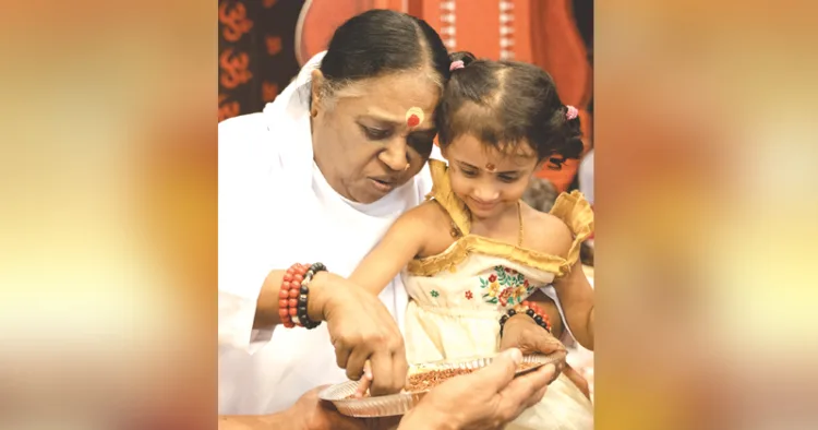 അമൃതപുരി മഠത്തില്‍ നടന്ന വിദ്യാരംഭച്ചടങ്ങില്‍ മാതാ അമൃതാനന്ദമയി ദേവി കുരുന്നിന് ആദ്യക്ഷരം കുറിക്കുന്നു