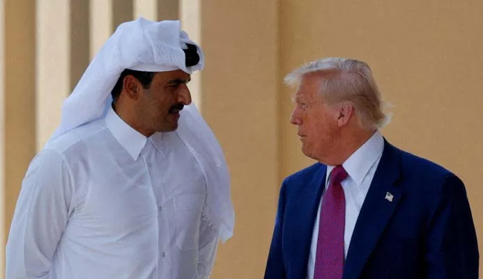 FILE PHOTO: U.S. President Donald Trump talks with Qatar's Emir Tamim bin Hamad Al Thani in Doha, Qatar, May 15, 2025. REUTERS/Brian Snyder/File Photo