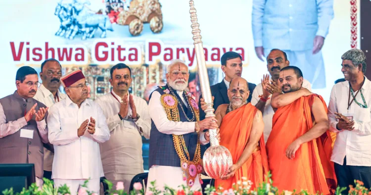 ഉഡുപ്പി ശ്രീകൃഷ്ണ മഠത്തില്‍ നടന്ന ലക്ഷകണ്ഠ ഗീതാപാരായണ ചടങ്ങിനെത്തിയ പ്രധാനമന്ത്രി നരേന്ദ്ര മോദിക്ക് പര്യായ പുട്ടിഗെ മഠാധിപതി സുഗുണേന്ദ്ര തീര്‍ത്ഥ സ്വാമിജി 'കടേഗോലു' സമ്മാനിക്കുന്നു