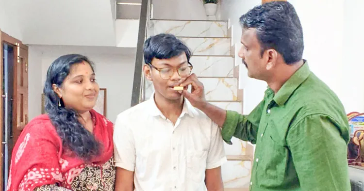 അഖിലേഷിന് അച്ഛന് രാജേഷും അമ്മ അഞ്ജുവും മധുരം നല്കുന്നു