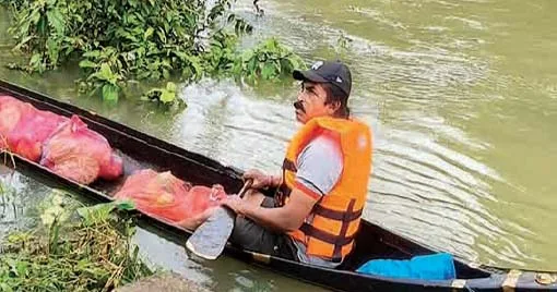 പ്രളയത്തില്‍ ദുരിതമനുഭവിക്കുന്നവര്‍ക്ക് ഭക്ഷ്യസാധനങ്ങള്‍ കൈമാറാന്‍ തോണിയില്‍ പോകുന്ന സുരേഷ്‌കുമാര്‍